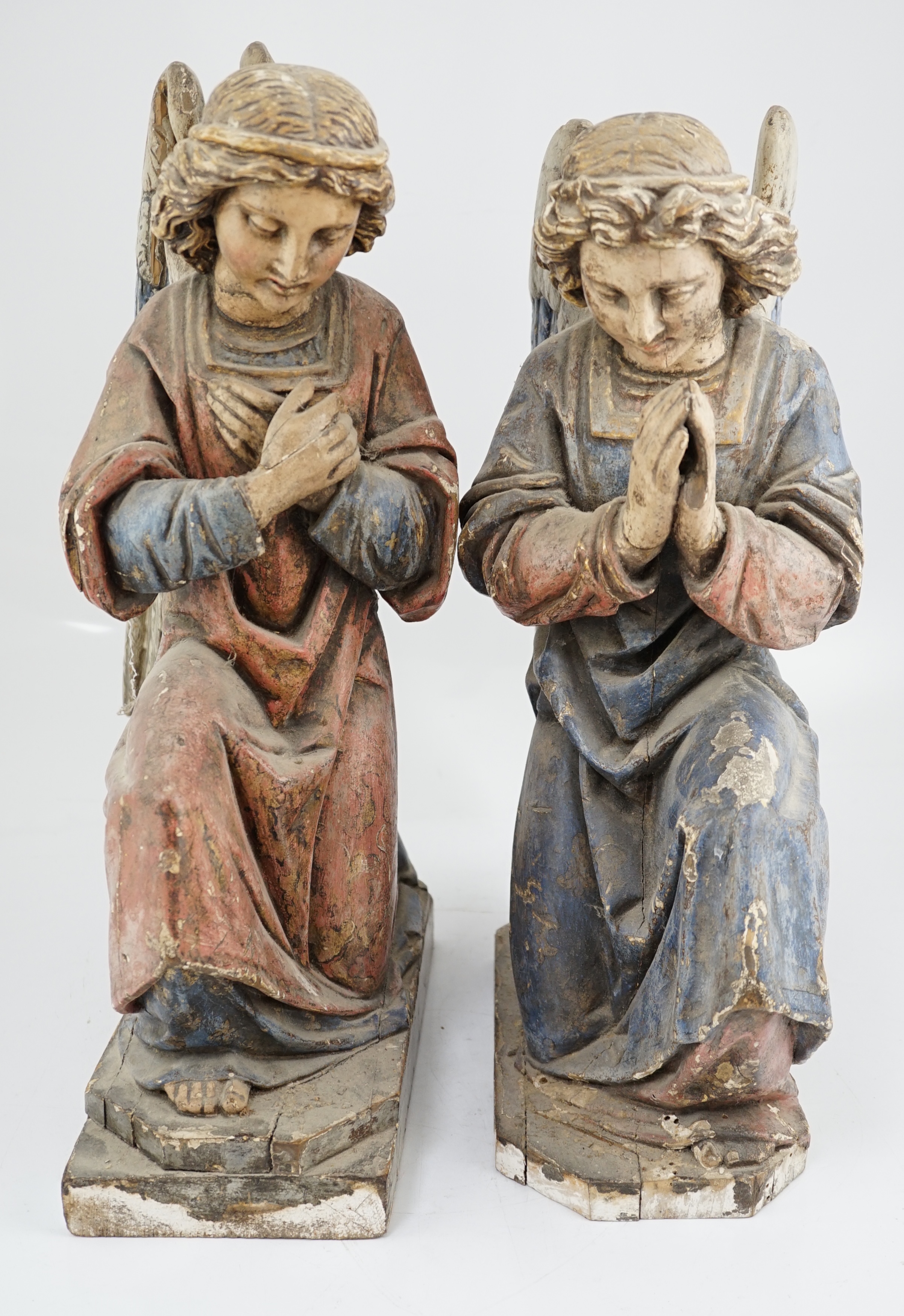 A pair of late 19th century polychrome carved painted pine praying archangels